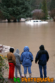 People Watching Car in Flood