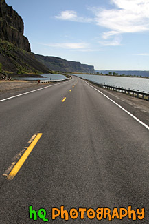 Road Between Lake and Cliff