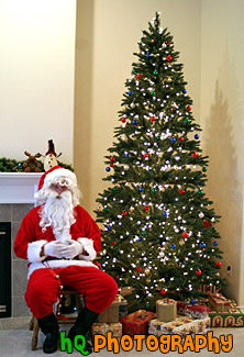 Santa Claus Sitting by Christmas Tree