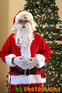 Santa Standing in Front of Christmas Tree