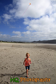 Little Girl Running on Beach with Kite