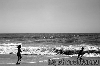 Kids Running Away from Ocean Waves black and white picture