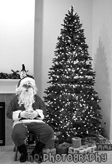 Santa Claus Sitting by Christmas Tree black and white picture