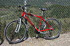 Red Mountain Bike Against Fence photo thumbnail