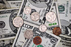 Coins on top of Money Bills photo thumbnail