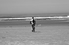 Black & White Man Riding Bike on Beach preview