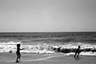 Black & White Kids Running Away from Ocean Waves preview