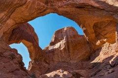 Man-Standing-in-Double-Arch-in-Arches-National-Park-3